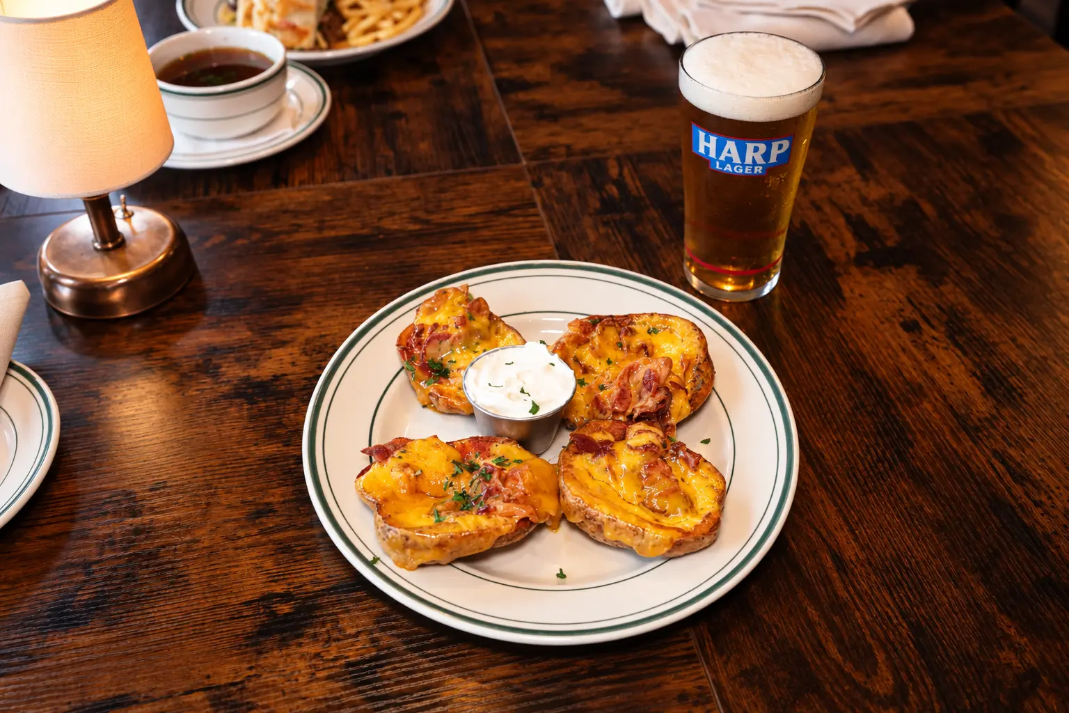 Loaded potato skins with sour cream and a Harp lager