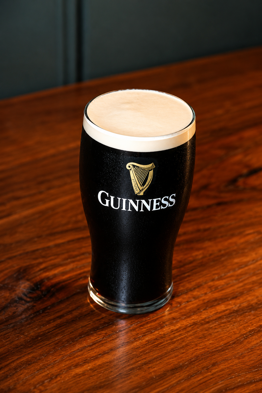 A pint of Guinness on a polished wooden bar at The Red Stag