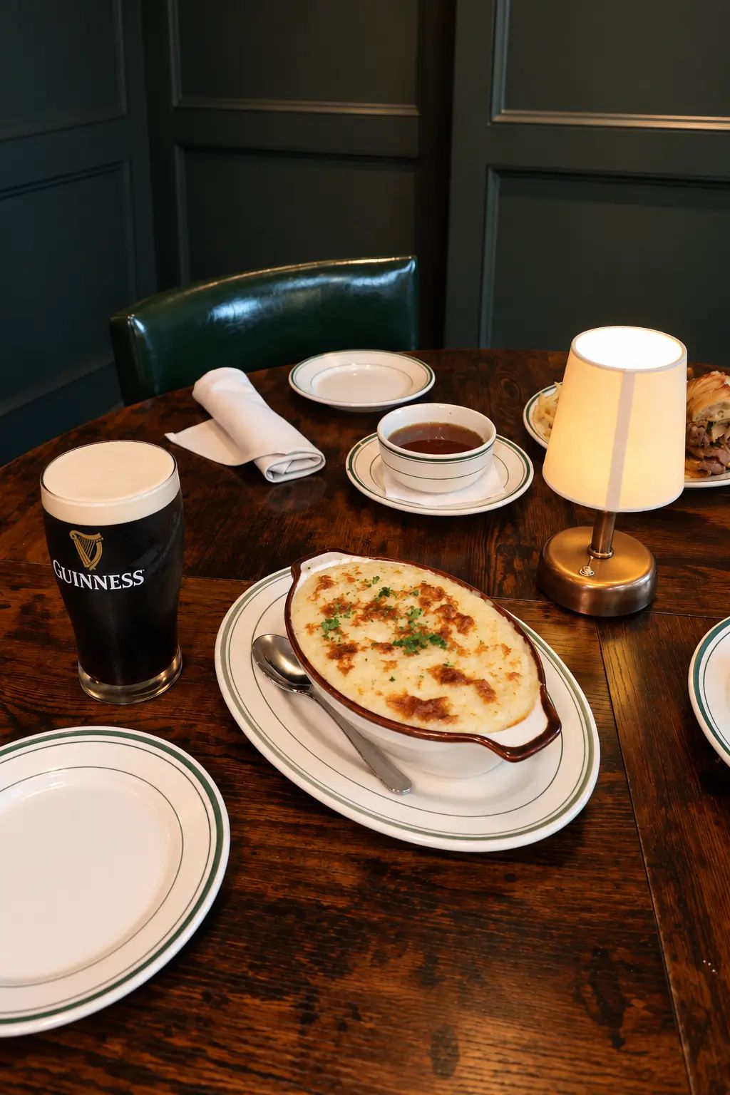 Shepherd's pie and a pint of Guinness on a warm wooden table