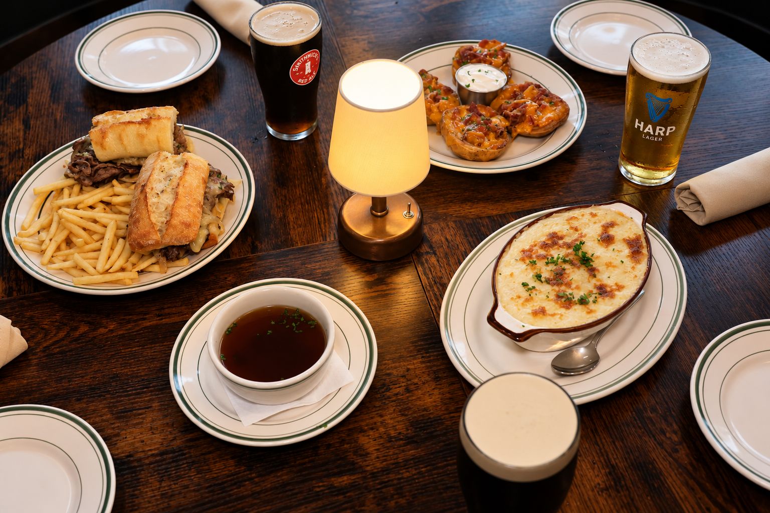 A table filled with tavern favorites and pints at The Red Stag